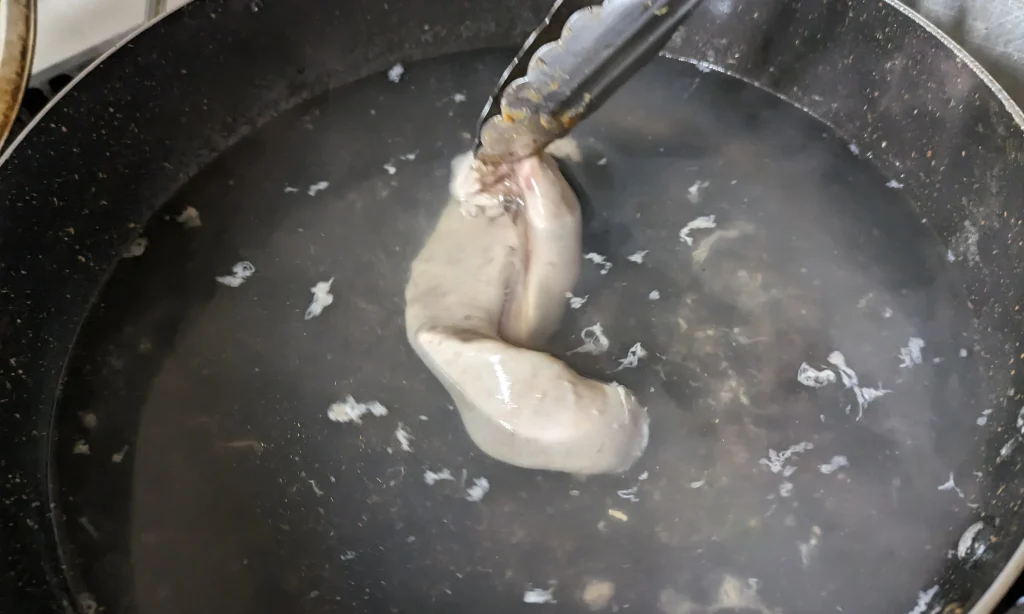 20分放置した後、水で塩を流し、沸騰したお湯にくぐらされた白子をあげる瞬間